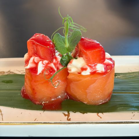 Involtini di salmone con fragola fresca, crema al formaggio e salsa alla fragola, su foglia di banano